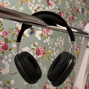 Svarta hörlurar med USB-kabel - Säljer ett par svarta hörlurar med vadderade öronkuddar och justerbart huvudband. Hörlurarna har en stilren design och kommer med en kort USB-kabel för laddning eller anslutning.
