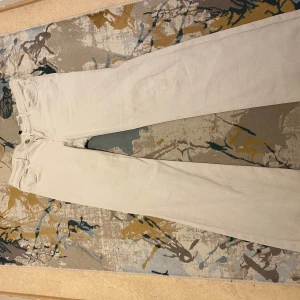 Beige jeansbyxor - Snygga beige jeansbyxor med en klassisk design. De har en rak passform och är lågmidjade, vilket ger en stilren look.  