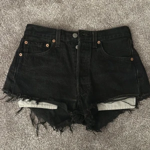 Svarta jeansshorts från Levi's - Säljer ett par svarta Levi's 501 jeansshorts med fransiga kanter. Säljs då dem inte passar mig