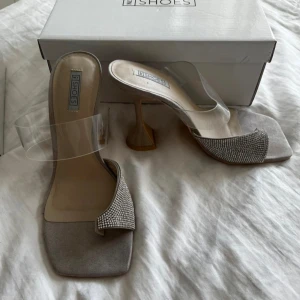 Eleganta klackskor med strassdetaljer - Snygga klackskor från Nelly med en elegant design. Nyskick, aldrig använda. 