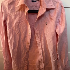 Rosa skjorta från Ralph Lauren - Säljer den då den inte passar mig längre , den är använd bara några fåtal gånger. Den är i bra skick den behöver bara strykas då den är lite skrynklig. 