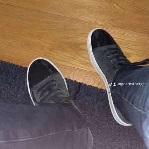 Svarta sneakers med vita sulor - Snygga svarta sneakers med vita sulor och snörning. Perfekta för en casual look. De har en stilren design med en blank finish på tån och en bekväm passform.