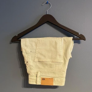 Beige shorts från 157 - Snygga ljus gröna shorts från 157 med klassisk design. De har en knappgylf och femficksmodell, perfekt för en avslappnad stil. Passar bra till varma dagar och ger en stilren look.