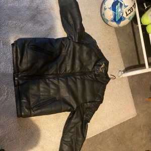 Svart skinnjacka - Snygg svart skinnjacka med dragkedja och två fickor med dragkedjor. Jackan har en quiltad design och långa ärmar. Perfekt för en cool och stilren look.