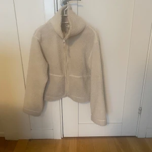 Teddyjacka H&M - Mysig vit teddyjacka med dragkedja framtill. Har en liten fläck på baksidan (dock inte testat att tvätta den) men ingen som märks. Säljes pågrund av att jag har andra liknande jackor.🥰🥰