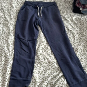 Mörkblå mjukisbyxor från Race Marine - Säljer ett par mörkblå mjukisbyxor från The Essentials. Byxorna har en bekväm passform med resår och snörning i midjan. Perfekta för en avslappnad dag hemma eller på språng.