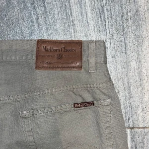 Beige byxor från Marlboro Classics - Snygga beige byxor från Marlboro Classics med klassisk design. Längd 105cm midjemått 44cm fotvidd 23cm. Finns på folkungagatan 142 Södermalm.