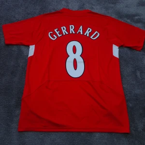 Liverpool FC | 2005 Champions League Final Tröja | Size: XL | Gerrard |  Ny, oanvänd - Liverpools matchtröja från den legendariska Champions League finalen 2005. Gerrard, nr 8 på ryggen. Storlek XL. Helt ny & oanvänd. Tröjan är en nyproducerad reprint i utmärkt kvalitet. Perfekt för alla Liverpool fans där ute !⚽  Skickas 1-3 dagar efter mottagen betalning. Har du frågor/funderingar är det bara att höra av dig! :)        