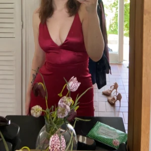 Röd balklänning med v-ringning - Säljer en elegant röd balklänning med djup v-ringning och ärmlös design. Perfekt för kommande studentbal. Använd en gång tyvärr en liten defekt men inget man ser med blotta ögat Skriv för bild eller andra frågor kring de🫶🏼jag är 169 lång och hade 10cm klackar här