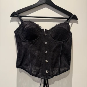 Korsett - Svart korsett i storlek S/M. Knäppning i fram och snörning i bak så den passar många storlekar!  Använd förra halloween endast så super fint skick!