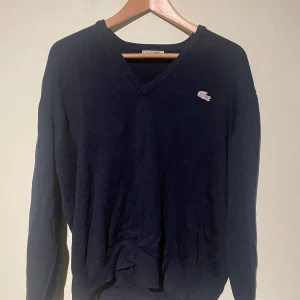 V-ringad Lacoste Tröja - Tja, Säljer nu en V-ringad Lacoste tröja i storlek S men kan även passa dom som har M. Använd ungefär 2 ggr och är i väldigt bra skick, och har en bra passform. Ställ gärna frågor!