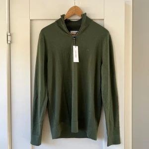 Helt ny stickad halfzip - Säljer denna snygga och helt nya stickade halfzip tröjan i 100% ull från Calvin klein. Nypris ca 2200kr. Säljer nu den till ett billigt pris så passa på! 