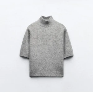 Grå stickad tröja - Säljer den här super snygga kortärmade stickade tröjan som har en liten polo. Strl M men passar som en xs/s. Den är väldigt liten i modell. 