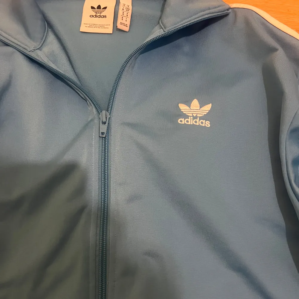 Säljer denna snygga ljusblå zipup tröjan från Adidas. Den är i jättebra skick. Strl s (herrstorlek) så den är mer baggy.. Tröjor & Koftor.