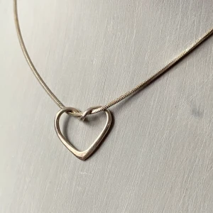 Elegant silverhalsband med hjärthänge - Säljer ett stilrent och elegant halsband i silver med ett öppet hjärthänge. Perfekt för både vardag och festliga tillfällen. Halsbandet har en smidig låsning baktill och en minimalistisk design som passar alla stilar. Ett måste för smyckesälskare! 💖stämplat 925
