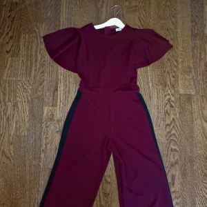 River Island Burgandy Body Suit - Säljer min lillasysters River Island Body Suit i färgen burgandy. Den är använd 2-3 gånger endast och borde passa flickor i 9-10 års åldern. Släpper för 299:-