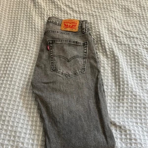 Grå Levis jeans w32 L32 - Säljer ett par snygga grå Levis jeans i klassisk stil. De har en normal passform och är perfekta för både vardag och fest. Jeansen är i bra skick och har den ikoniska Levis-lappen på baksidan. Perfekta för höst och vår!