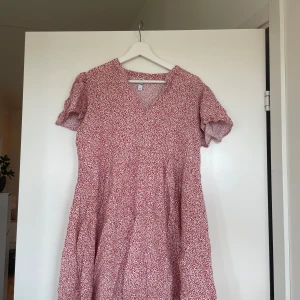 Rödvit blommig kortklänning från JDY - Fin tunika/kort klänning i blommigt material. Röd och vit.