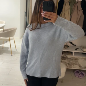 Ljusblå stickad tröja  - Supermysig ljusblå stickad tröja från Amisu med rund hals och ribbade muddar. Perfekt för lager-på-lager och chill dagar. Långärmad och loose fit för en avslappnad vibe.