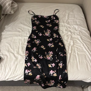 Svart satin blomsterklänning - Väldigt fin svart satin blomkläning, köpt i Nya Zeeland, använd en gång!