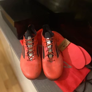 ADIDAS F50 ELITE AG VIVID HORIZON - RÖD/ SVART/SILVER - PRIS KAN DISKUTERAS! Säljer mina Adidas F50 Elite AG i toppskick. Endast lite för stora för mig. ✅ Originalkartong, skopåse & extra innersula ingår ✅ Sällsynt färg & modell ✅ Endast ett borttaget tryck på sidan, påverkar ej spelet  Pris sätts lågt p.g.a. trycket. Först till kvarn!