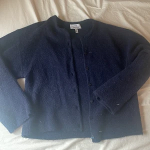 Mörkblå kofta från & Other Stories - Mysig mörkblå kofta från & Other Stories med rund halsringning och knappar framtill. Koftan är stickad och har långa ärmar, perfekt för lager-på-lager under kyliga dagar. Enkel och stilren design som funkar till många outfits. Koftan är knappt använd så skicket är super!