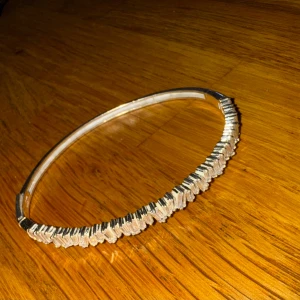 Glittrigt silverarmband med stenar - Snyggt armband i äkta silver med glittriga rektangulära stenar längs ovansidan. Armbandet har en stilren och modern design som sticker ut och passar perfekt för dig som gillar att glänsa lite extra. 