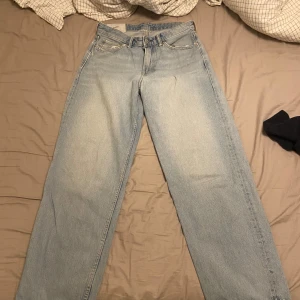 Ljusblå loose jeans från H&M - Säljer ett par ljusblå loose fit jeans från H&M. De har klassisk femficksdesign, raka ben och en avslappnad passform. Perfekta för dig som gillar en chill och trendig look. Tillverkade i jeansmaterial.