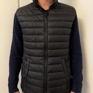 Svart dunväst från McKinley  - Säljer en svart, quiltad dunväst från McKinley i storlek S. Västen har dragkedja framtill, ståkrage och två fickor på sidorna. Perfekt för lager-på-lager och enkel att matcha med olika outfits.