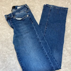 Blå jeans från Vero Moda, 26/32 - Snygga blå jeans från Vero Moda i klassisk femficksmodell. Jeansen har normal passform, raka ben och är tillverkade i mjukt denimtyg med lite stretch. Perfekta till sneakers eller boots och funkar året runt.