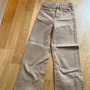 Beiga wide jeans från  lager 157, XXS - Snygga beiga jeans från 157 i storlek XXS. Modellen har raka, vida ben och klassisk femficksdesign med hög midja 