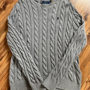 Grå kabelstickad tröja Polo Ralph Lauren - GRÅ KABELSTICKAD RALPH LAUREN. SKICKET ÄR PERFEKT 10/10 INGA TECKEN PÅ DEFEKTER ÖVERHUVUDTAGET 👌 100% BOMULL ‼️ 69 CM PÅ LÄNGDEN 📏O 45 CM PÅ BREDDEN 📐HÖR AV ER PRIS GÅR SÅKLART O DISKUTERAS 👍