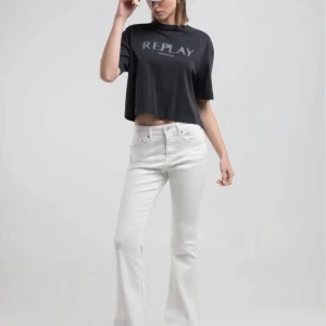 Vita bootcut jeans från Replay - Snygga vita jeans från Replay med bootcut-modell och klassisk femficksdesign. Jeansen är tillverkade i ett mjukt bomullstyg med lite stretch. Perfekta för dig som vill ha en fräsch och trendig look. Storlek 25/30