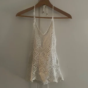 Virkat figurnära linne - Vitt väldigt figurnära virkat linne. Strlk XS/S. kan knytas som halterneck och som vanliga straps 