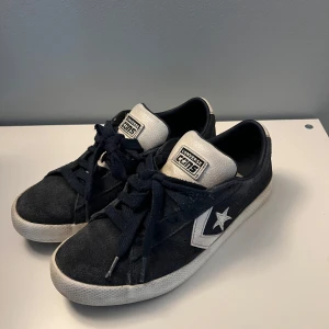 Blåa Converse sneakers i mocka - Säljer ett par blåa Converse sneakers med vit sula och vita detaljer. Skorna har klassisk stjärnlogga på sidan, snörning och är tillverkade i mocka med inslag av syntet. Perfekta för dig som gillar en tidlös och sportig stil. Det ser ut som att dem är svarta på bilderna men dem är blåa
