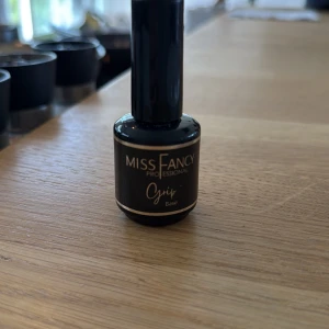 Miss Fancy Professional Grip Base - En svart flaska med Miss Fancy Professional Grip Base, perfekt som bas för naglar. Snygg och stilren design med guldiga detaljer. Passar dig som vill ha en bra grund för att få naglarna att sitta bättre och längre. Helt oanvänd!!