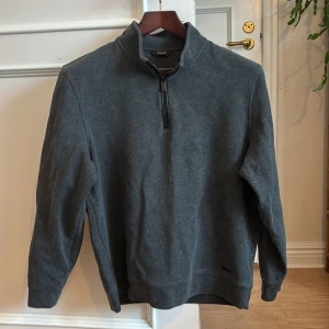 Mörkgrå half zip tröja Massimo Dutti - Snygg mörkgrå tröja från Massimo Dutti i storlek M. Modellen har en hög krage och half zip-dragkedja framtill. Materialet är mjukt och känns som bomull, perfekt för chill dagar. Långärmad och enkel design utan mönster eller extra detaljer. Osäker på om modellen är för män eller kvinnor så valde unisex. Dock är den nog lite liten för en manlig M 