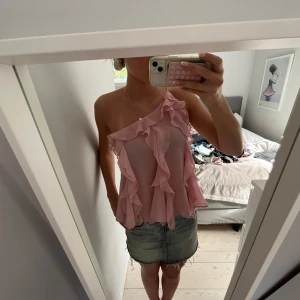 Rosa oneshoulder volangtop - Säljer en superfin rosa topp med volanger och oneshoulder-design. Luftigt tyg som ger en skön känsla och snyggt fall. Perfekt för dig som gillar trendiga detaljer.🤗🤗