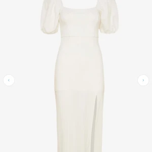 Vit långklänning med puffärmar Aldrig använd  - Supersnygg vit långklänning från ginatricot med puffiga kortärmar och fyrkantig urringning. Klänningen har en slits framtill som ger extra edge och är gjord i mjuk bomull. Perfekt för dig som gillar stilrena och trendiga plagg med lite volym på ärmarna. Aldrig använd bara testad passar någon som har  S eller  M. 