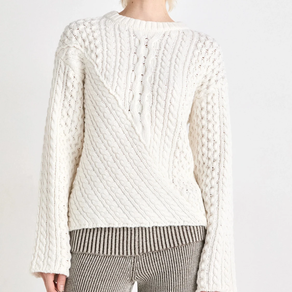 Vit stickad tröja med kabelmönster
