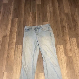 Ljusblå straight jeans från STR - Säljer ett par ljusblå jeans från STR i klassisk straight fit. Jeansen har fem fickor, normal passform och är tillverkade i jeansmaterial. Perfekt för dig som gillar en enkel och clean look med lite retrovibe.