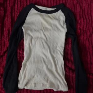Vit och svart långärmad tröja Brandy Melville - Säljer en ribbad långärmad tröja från Brandy Melville med vit kropp och svarta ärmar. Tröjan har en klassisk baseballstil med rund hals och slim passform. Perfekt för dig som gillar enkel och stilren design.🐆💋💋