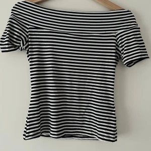 Offshoulder topp  - Randig offshoulder topp med svart och vitt. Kortärmad och lite tight passform.