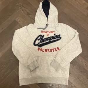 Vit champion hoodie - Säljer en ljusgrå hoodie från Champion i storlek Large men sitter exakt som en M. Den är i mycket bra skick och använt sparsamt, perfekt till sommarkvällar! 🤗hoodien har ett tryck på som får den att se snyggt vintage ut vilket är populärt! Kom DMs vid minsta fundering, svarar gärna på frågor! 😁🙏