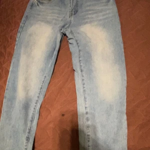 Ljusblå  jeans - Säljer ett par ljusblå skinny jeans med coola slitningar och blekta detaljer på framsidan och baksidan. Klassisk femficksmodell med normal passform och smalare ben. Perfekt för dig som gillar en avslappnad streetstil.