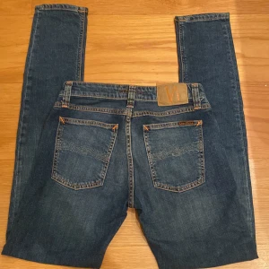 Blå skinny jeans från Nudie Jeans - Säljer dessa feta mörkblå/blå nudie jeans. De är skinny har en bra passform. Storlek 27/32.