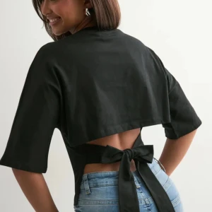 Svart topp med knyt och öppen rygg - Superfin topp från Nelly. Storlek Xs men passar även S. Helt ny. Det går bra att använda köp nu💕