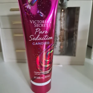 Victoria's Secret Pure Seduction Candied - Säljer en Victoria's Secret Pure Seduction Candied fragrance lotion i en snygg metallic rosa tub med godisdetaljer. Innehåller 236 ml och har doft av plommon och söt mysk. Tuben är vegansk och har en lyxig känsla, perfekt för dig som gillar söta dofter. helt ny och öppnad.