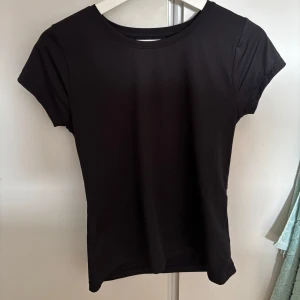 Svart tränings t-shirt - Svart t-shirt från SOC med korta ärmar och rund hals. Baksidan har ett meshparti för extra ventilation, perfekt för träning. Materialet är mjukt och stretchigt syntet som passar bra när man tränar. 💕