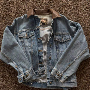 Jeansjacka från Express EXP med skinnkrage - Säljer en klassisk blå jeansjacka från Express EXP i storlek S. Jackan har en snygg brun skinnkrage, två bröstfickor med knappar och coola detaljer i metall. 